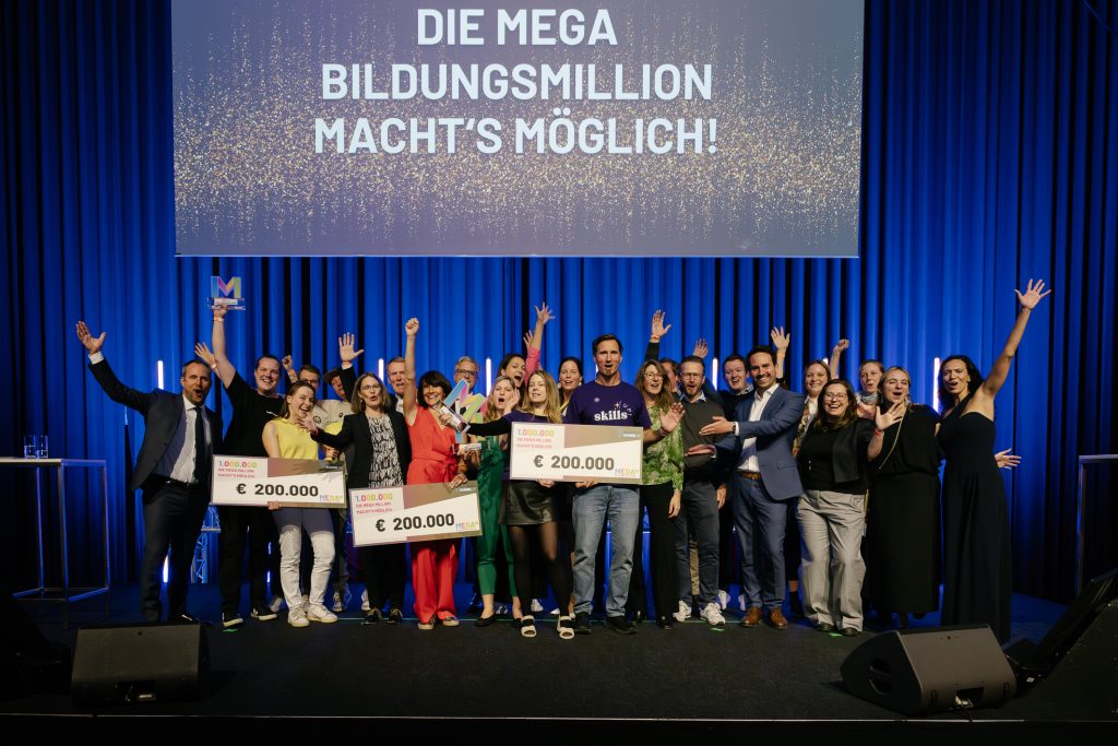 Skills-UP! gewinnt TOP 3 bei der MEGA Education Million 2025 — Dr. Stefan Bauers Team auf der Bühne mit €200.000-Schecks